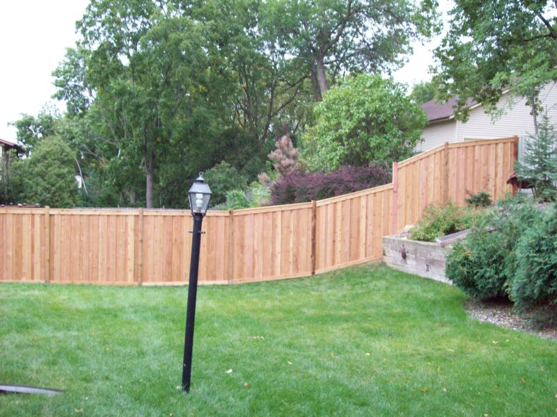 Cedar framed batten board privacy fence installation Minnesota