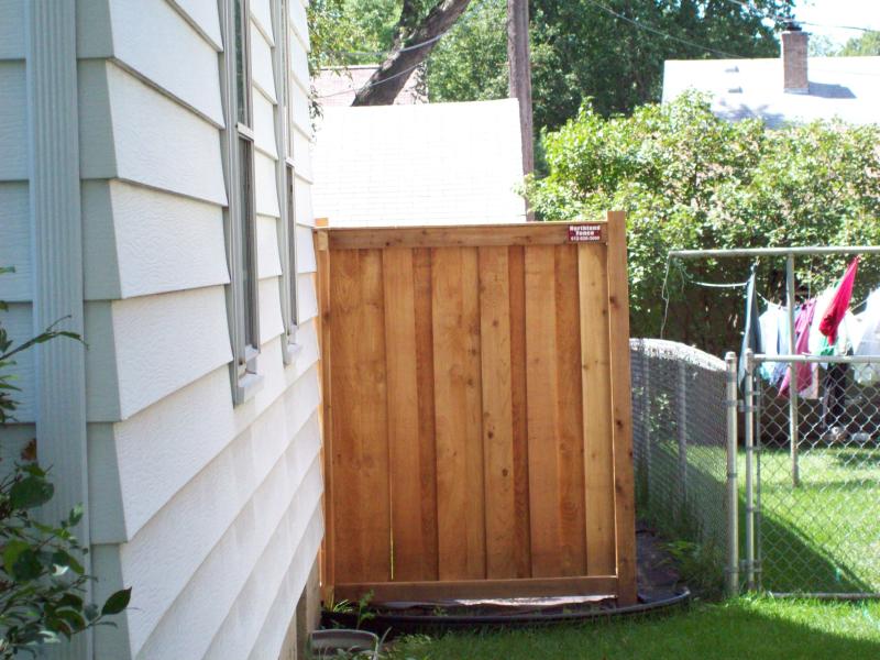 Cedar framed batten board privacy fence installation Minnesota
