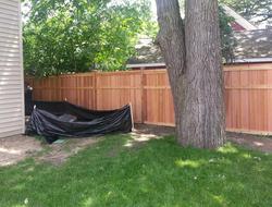 Cedar framed batten board privacy fence installation Minnesota